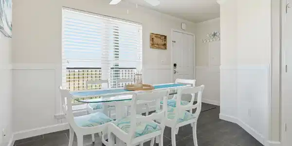 Image 4: Bright dining area with a coastal theme. The room