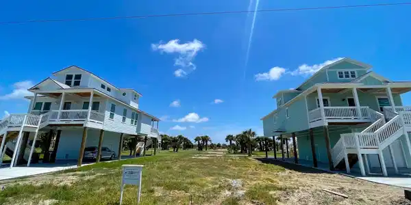 Image 2: This photo shows two elevated coastal homes with l