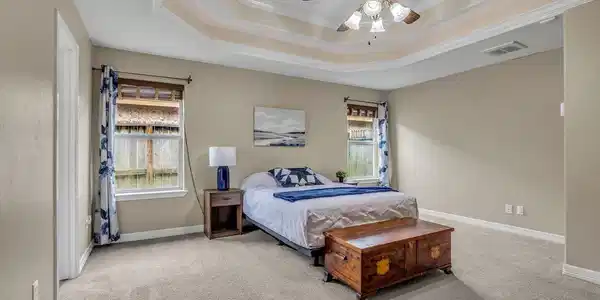 Image 4: Primary bedroom featuring an elegant tray ceiling.