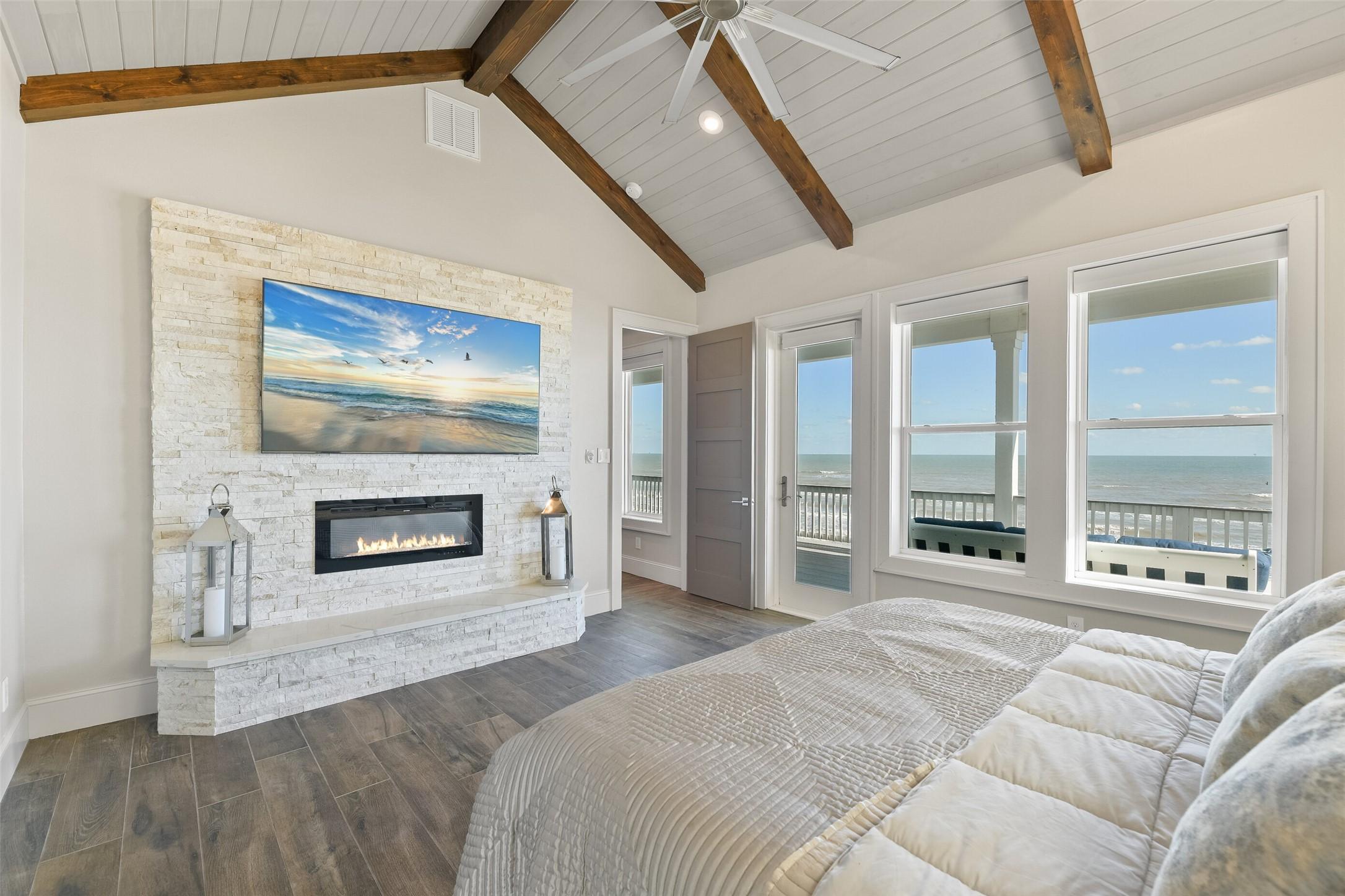 Image 2: The primary bedroom features a custom gas fireplac