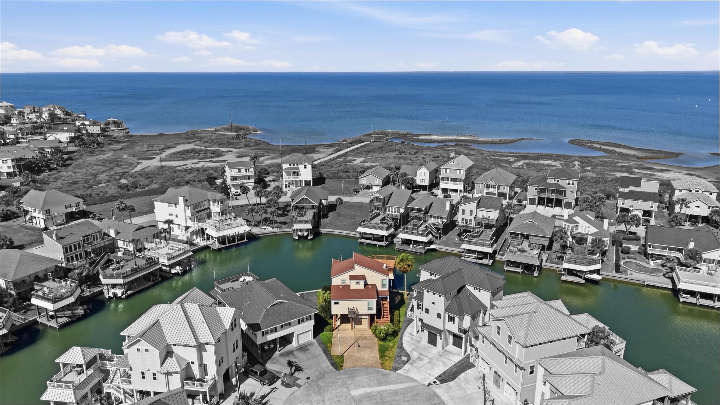 Image 1: Aerial view of a canal-front home with direct bay