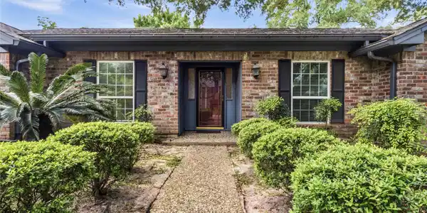 Image 3: Charming curb appeal with mature landscaping and a