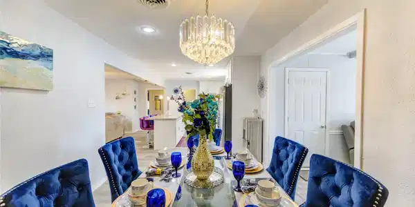 Image 2: The dining room features a beautiful chandelier an