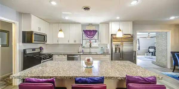 Image 3: This modern kitchen features granite countertops,