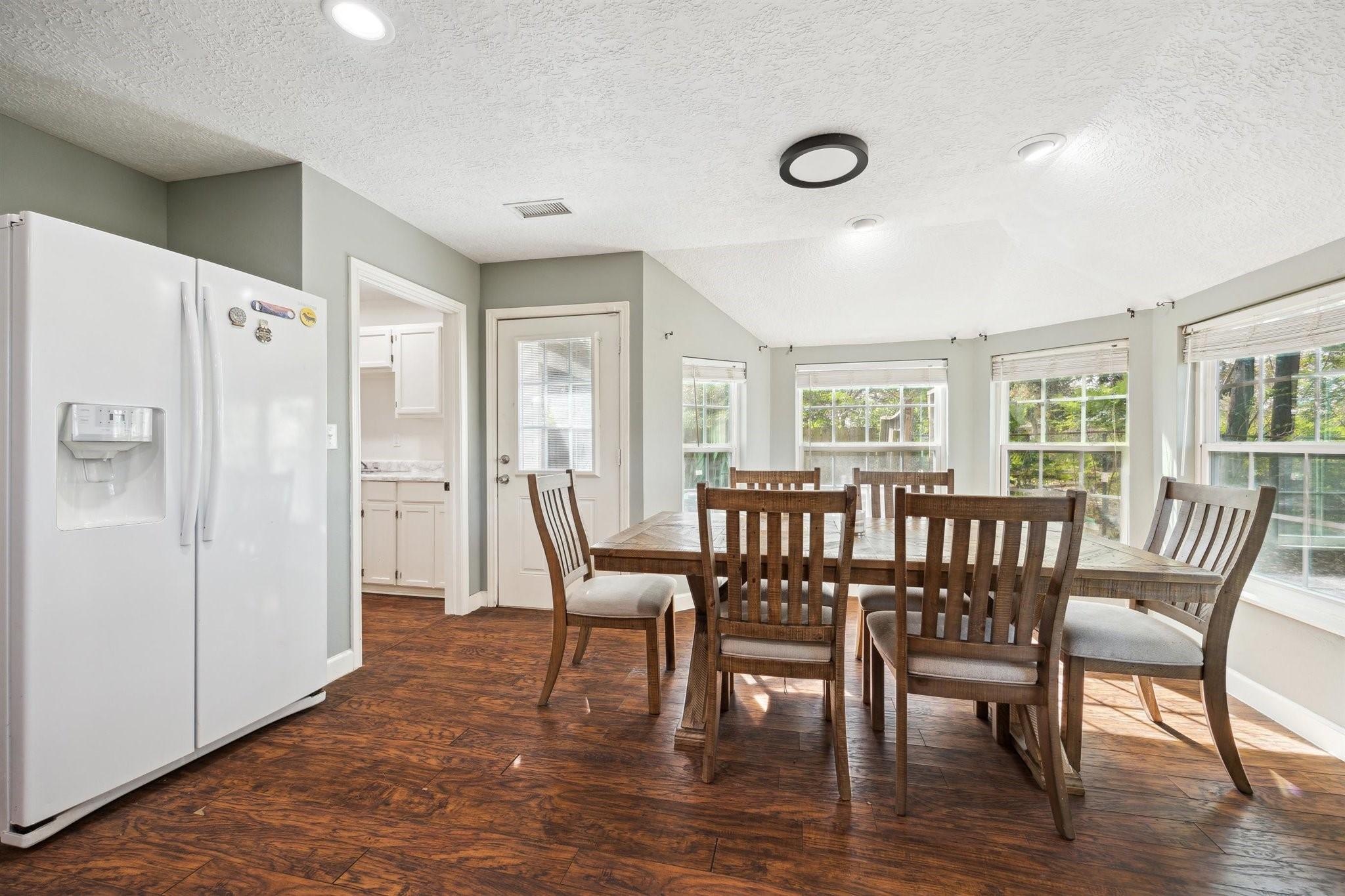 Image 3: Bright dining area surrounded by windows that fill