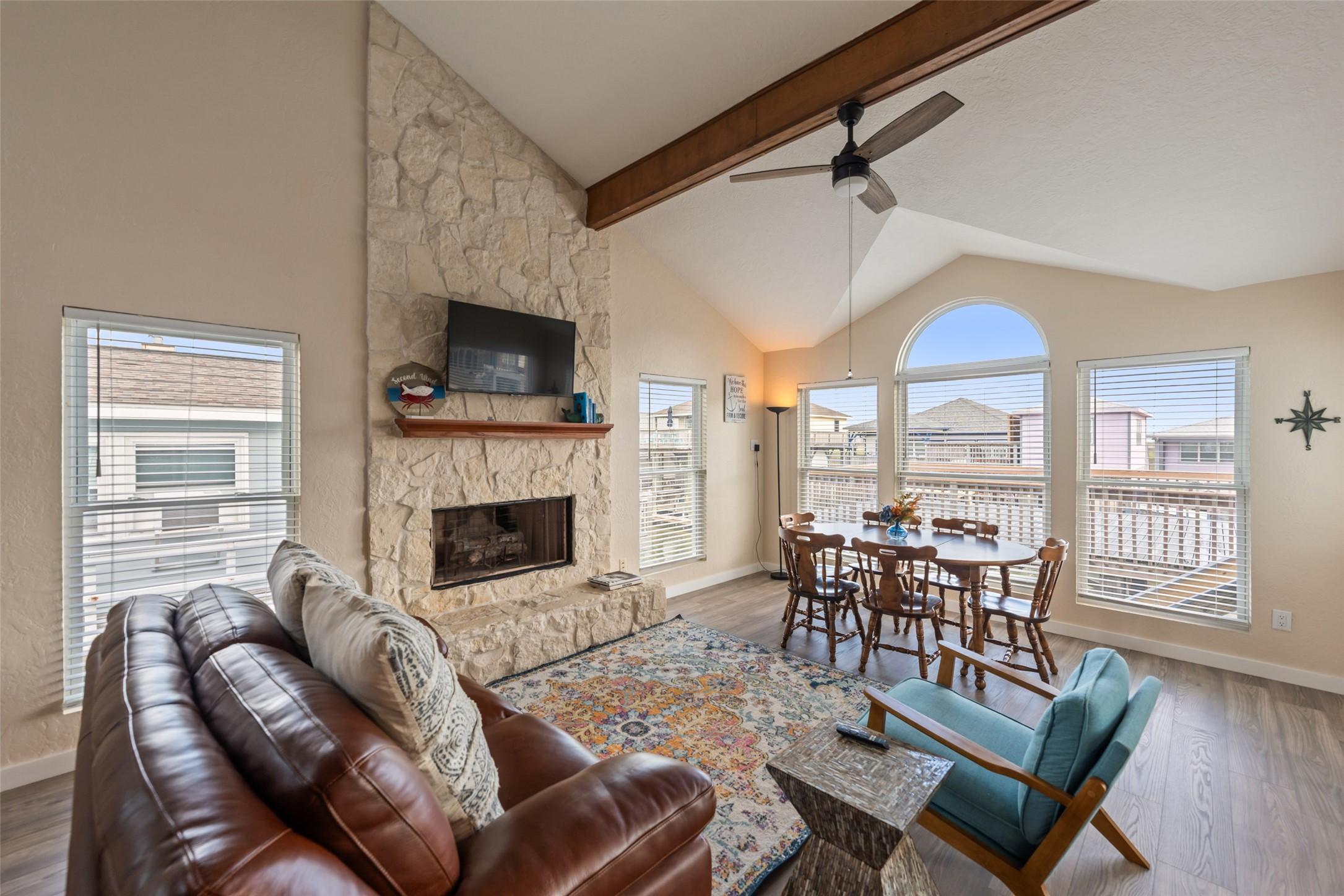 Image 4: Family room features a stone fireplace and abundan