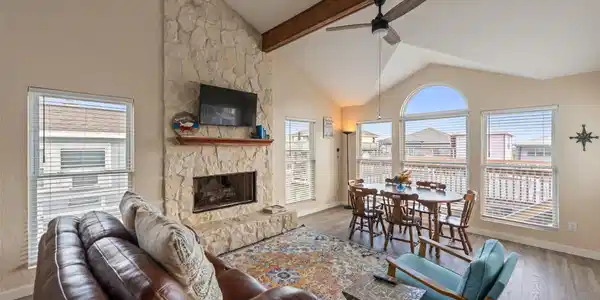 Image 4: Family room features a stone fireplace and abundan