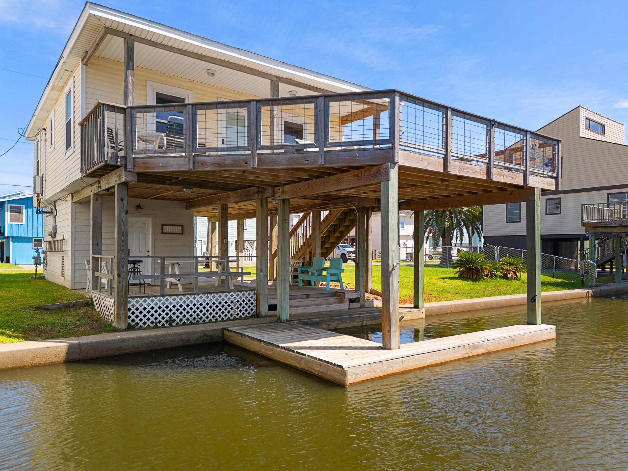 Image 1: This charming waterfront home features an elevated