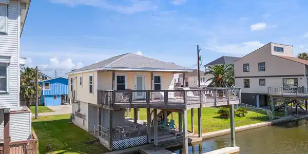 Image 3: This waterfront home features a raised deck with d