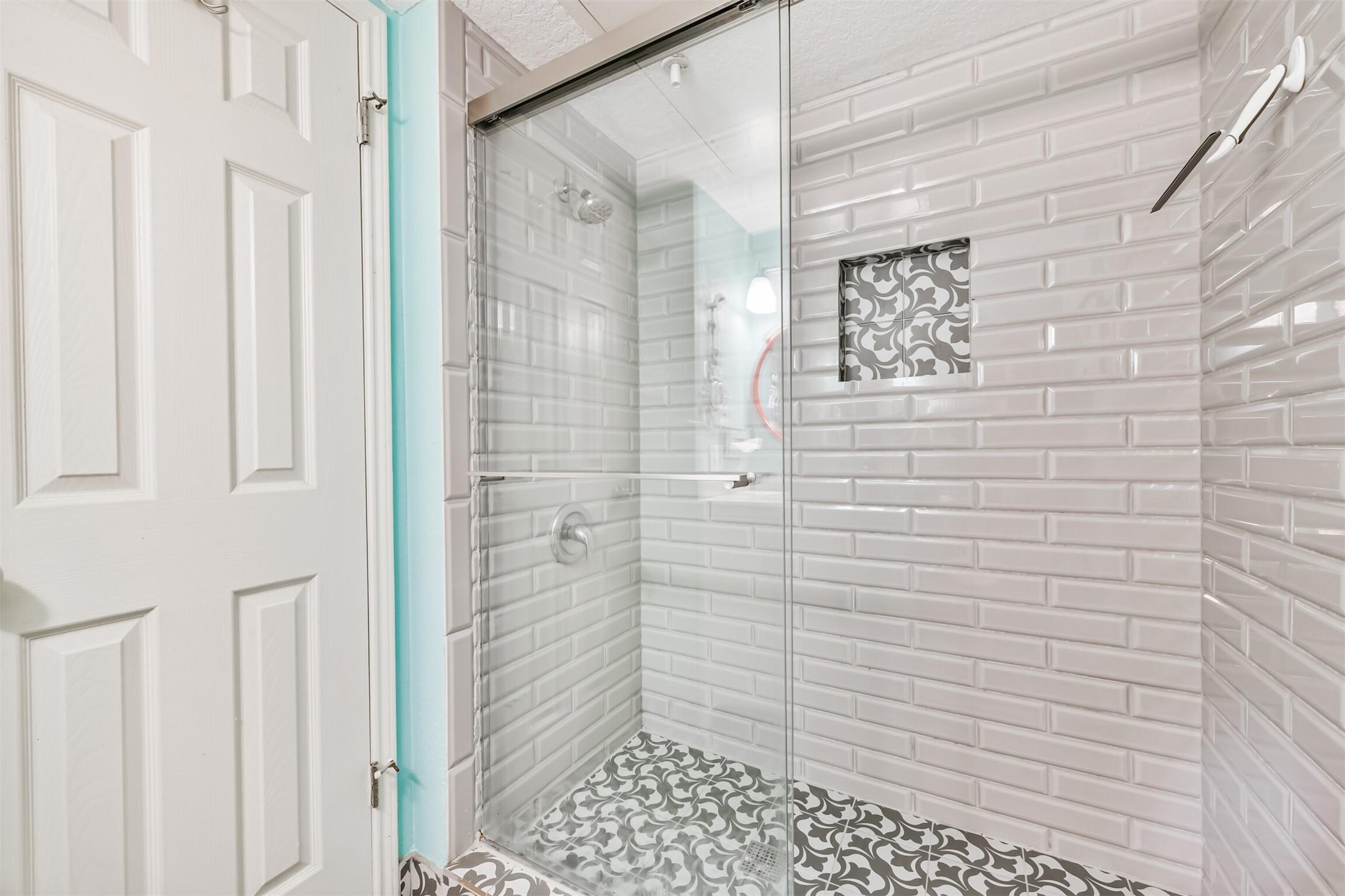 Image 4: Updated shower with glass door, subway-style tile,