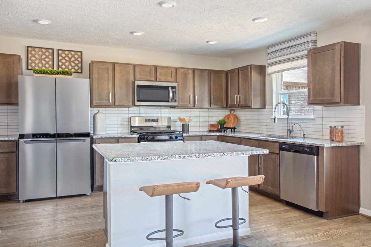 Image 4: This spacious kitchen offers rich wood cabinetry,