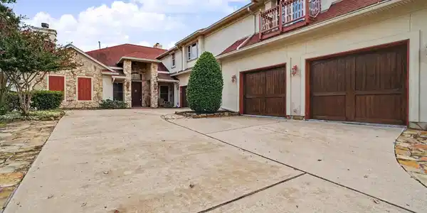 Image 4: Four car garage, long extended driveway leading to