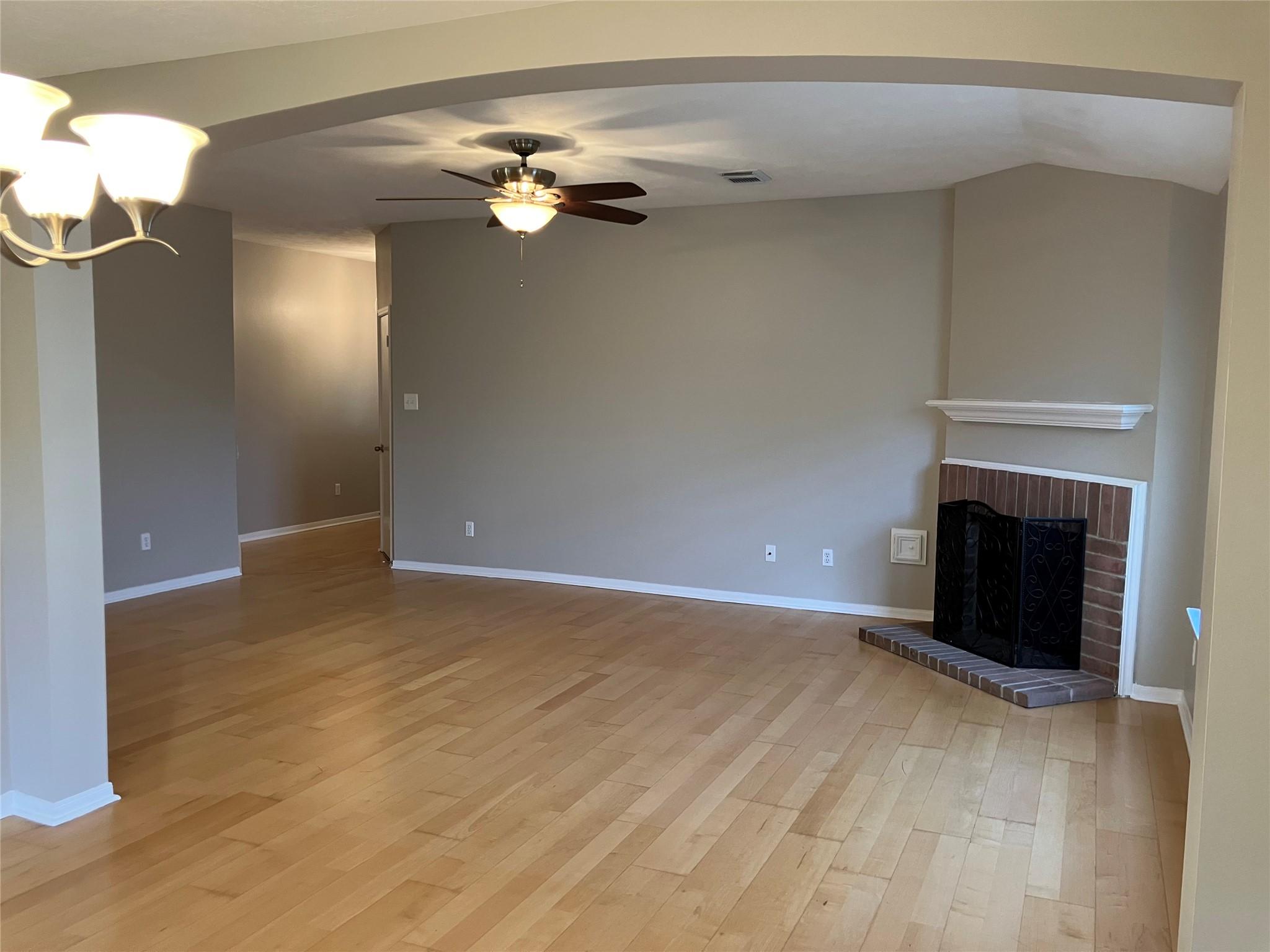 Image 4: Spacious living area with wood flooring, neutral w