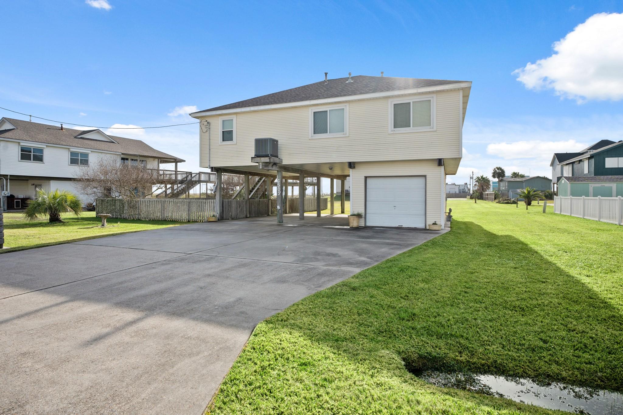 Image 2: Elevated home with a spacious driveway and single-