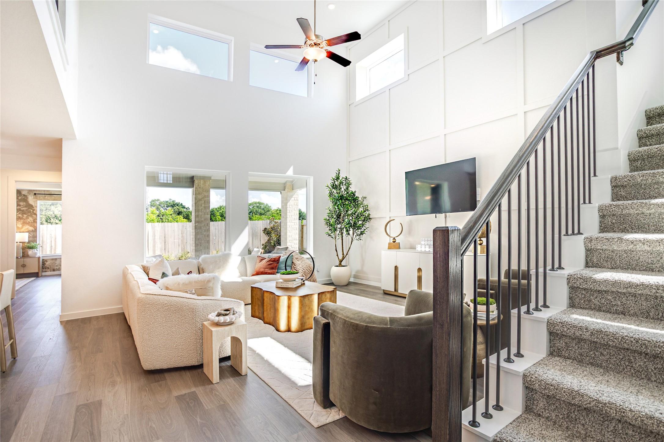 Image 1: The spacious living room features high ceilings an