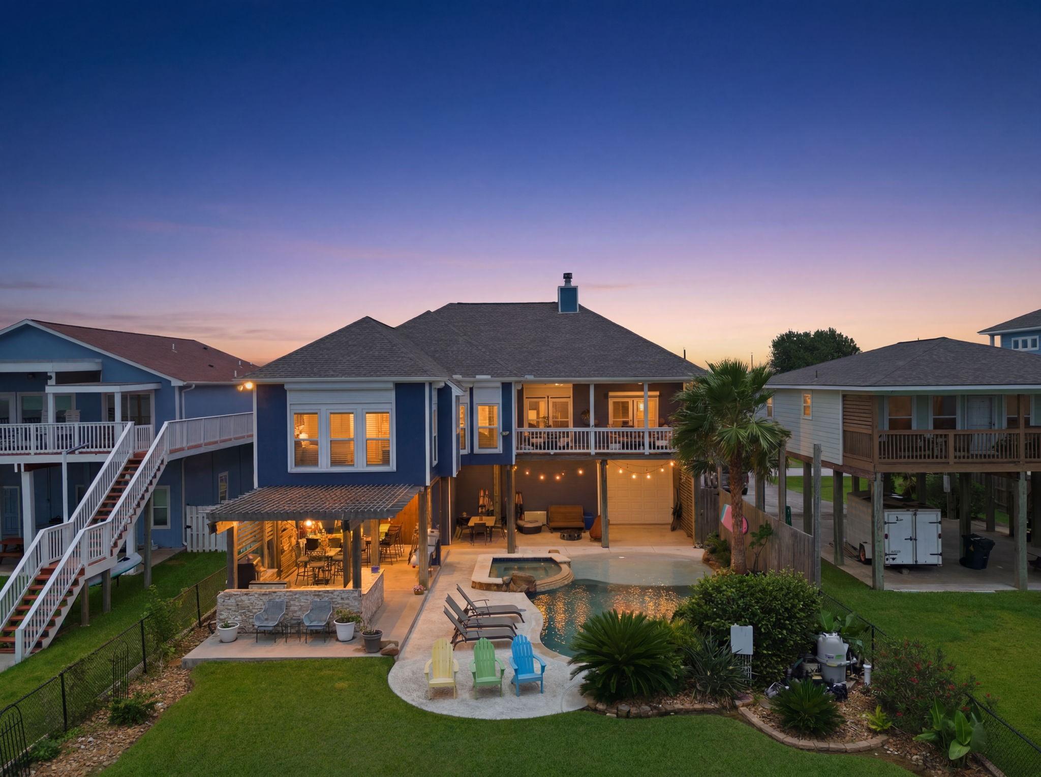 Image 2: Back View with Sparkling Pool and Outdoor Kitchen