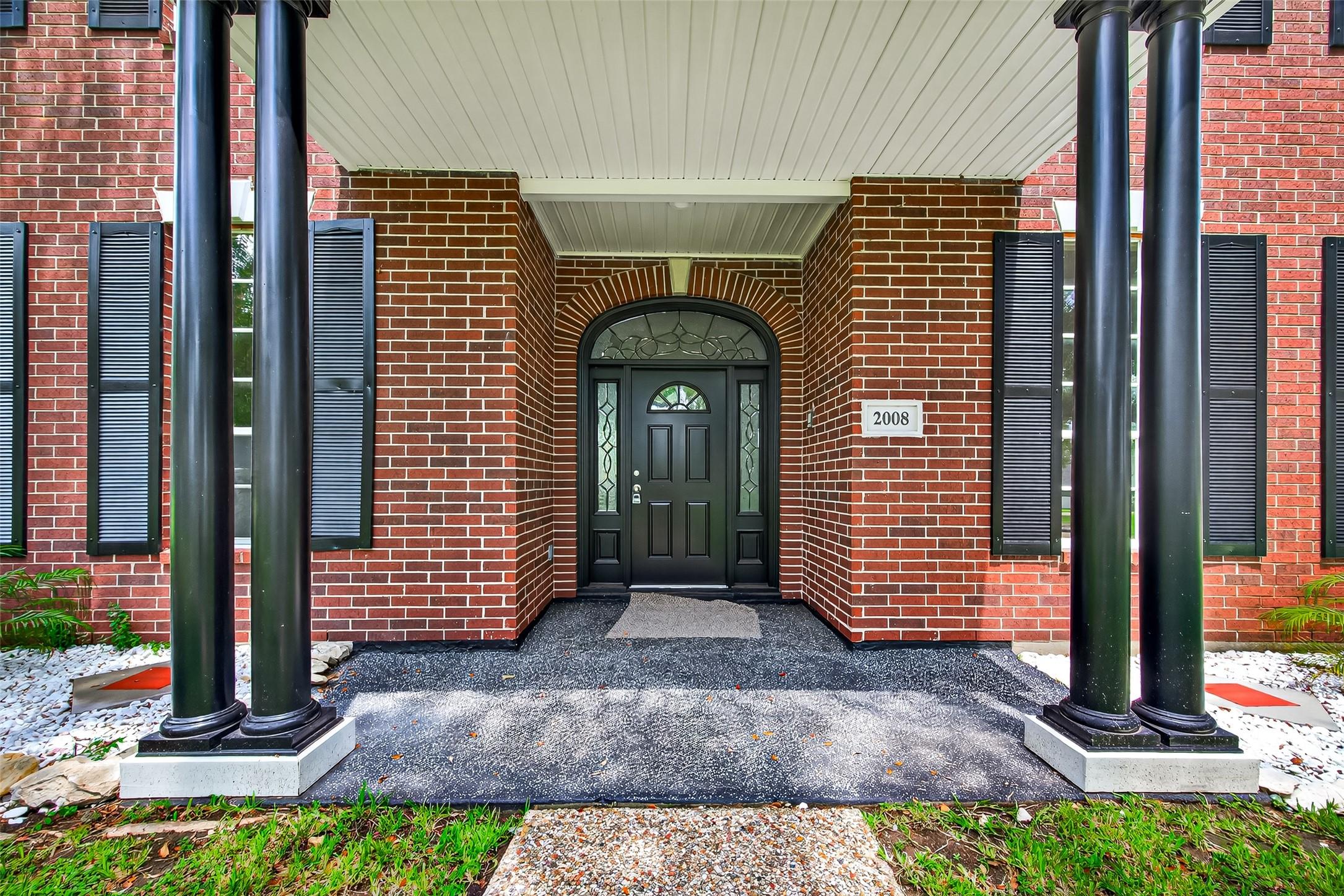 Image 3: Elegant brick entryway with classic black columns