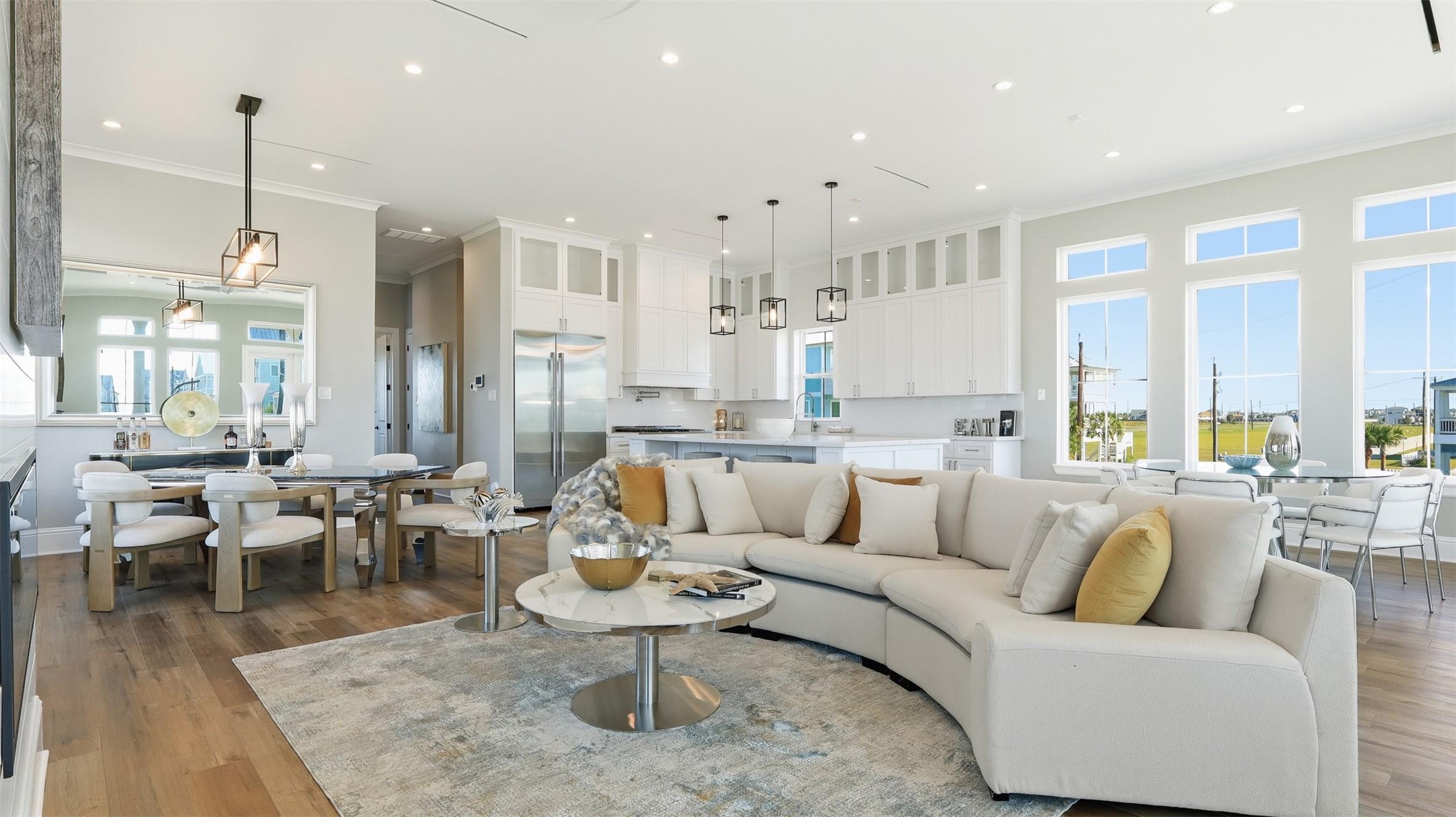 Image 3: This spacious, open-concept living area features a