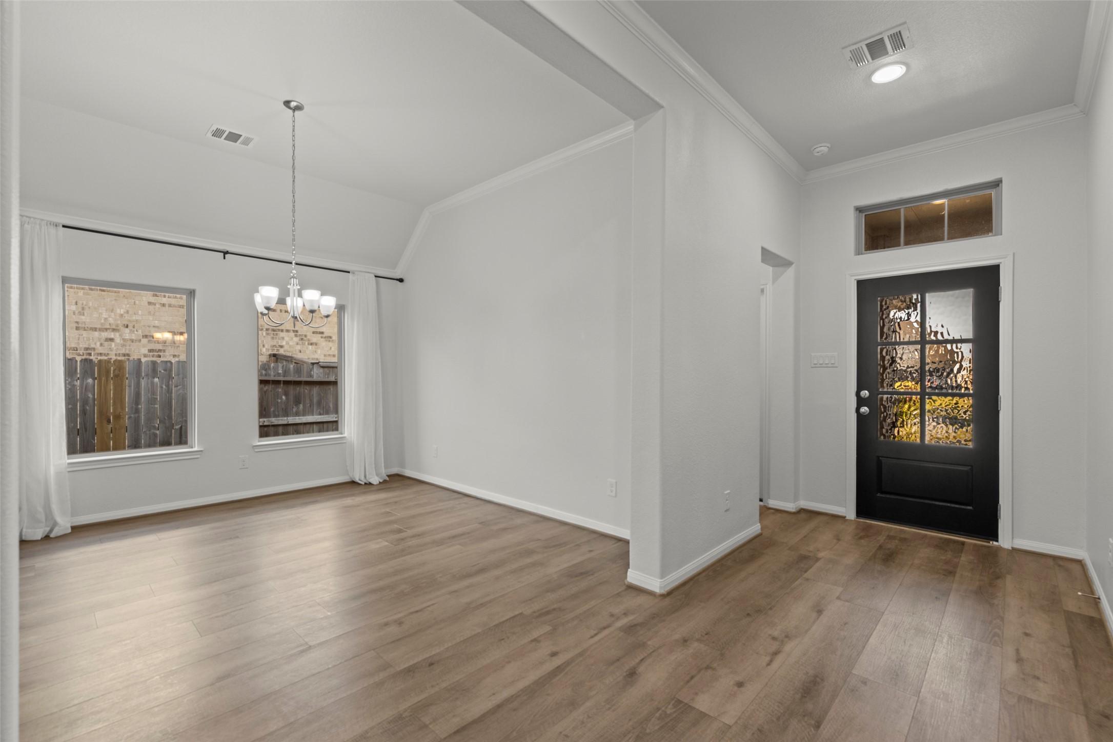 Image 3: Bright entry and dining area with wood flooring, l
