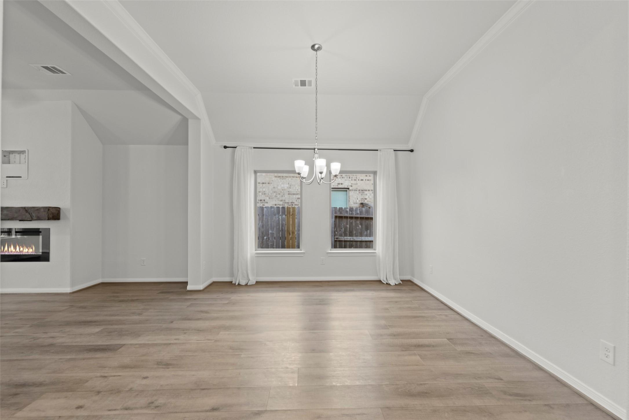 Image 4: Open dining space with wood flooring, large window