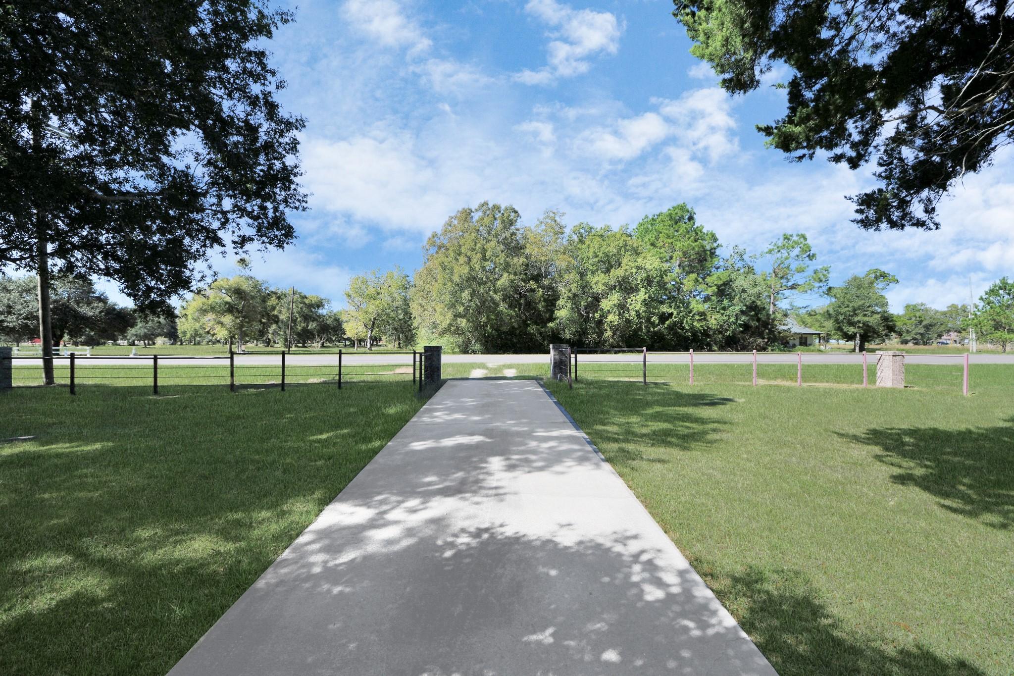 Image 4: A long, private driveway leads into the property,