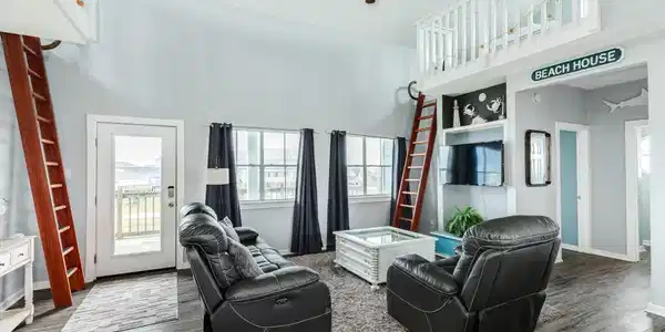 Image 3: Bright and airy living area features soaring ceili