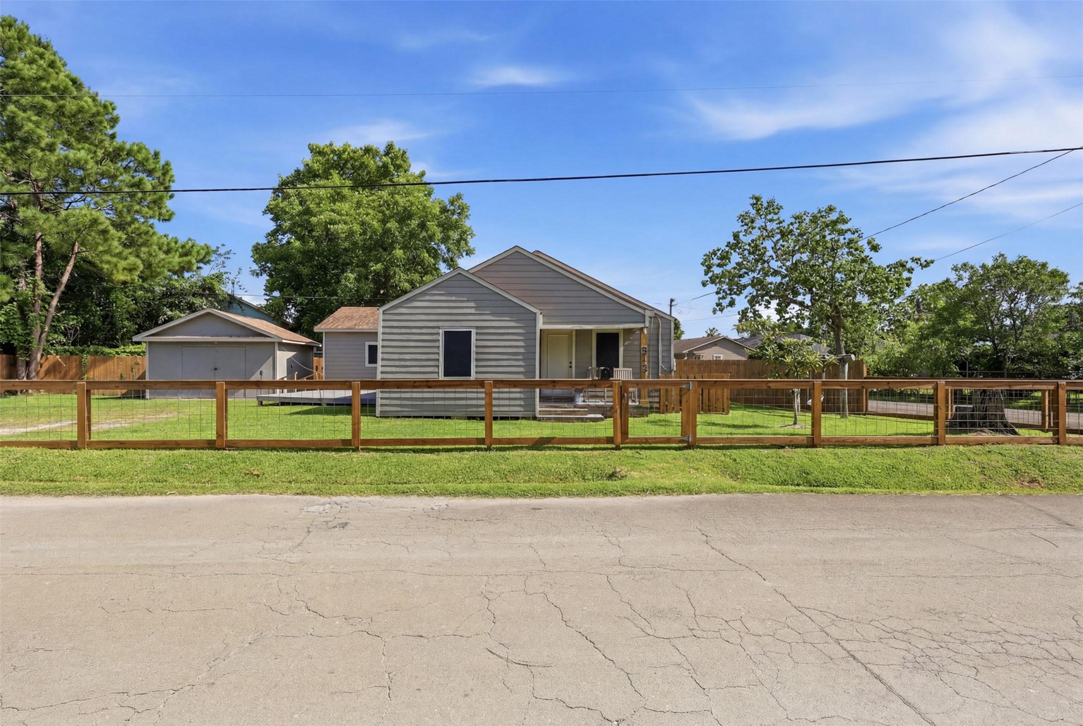 Image 2: Front view of home with fence and electric gate