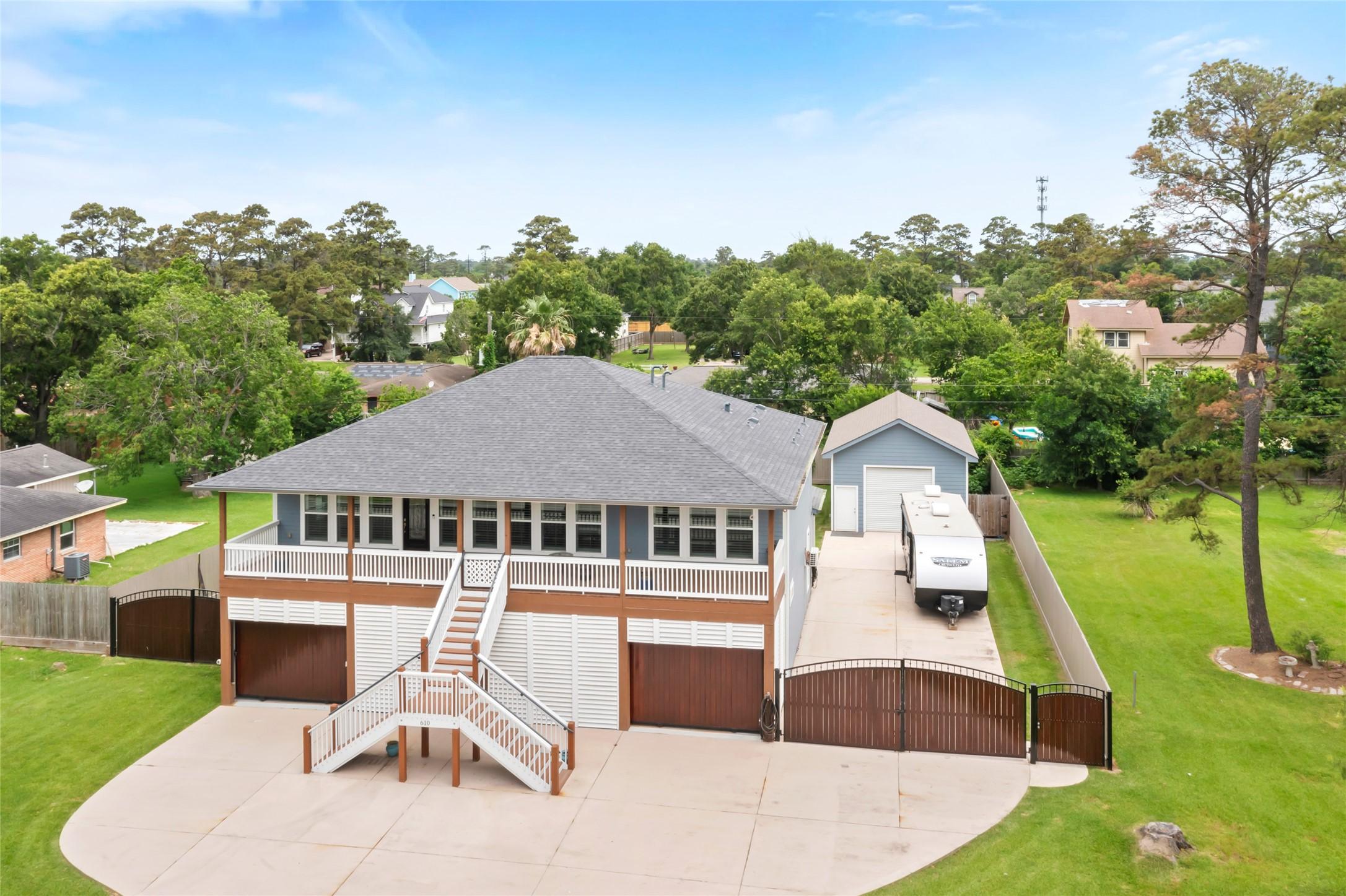 Image 1: This elevated home features a spacious front porch