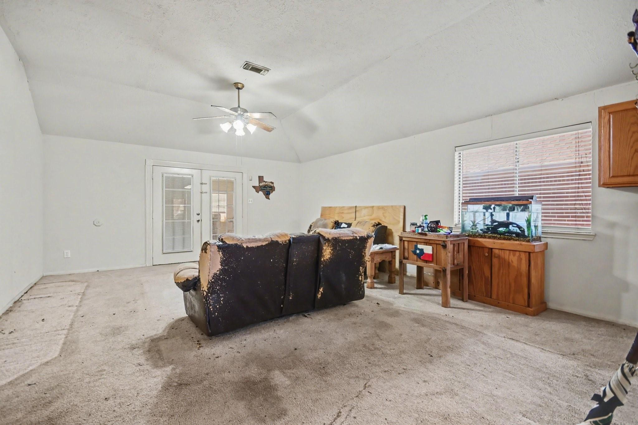 Image 3: Spacious living room with high ceiling, fan, and n