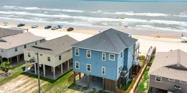 Image 2: This beachfront property features a charming blue,
