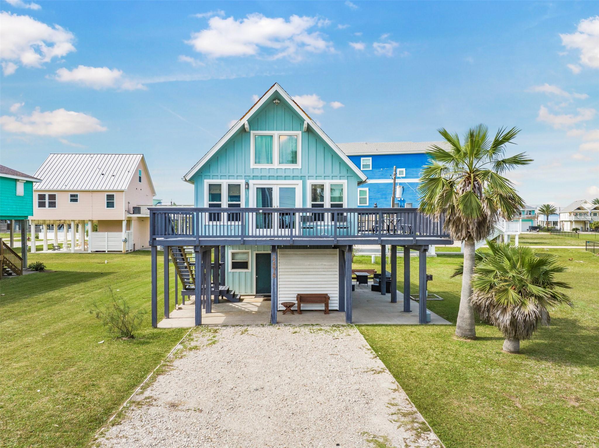 Image 2: This charming coastal home features a raised desig