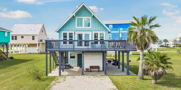 Image 2: This charming coastal home features a raised desig