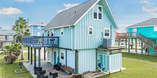 Image 4: This charming coastal home features a vibrant blue