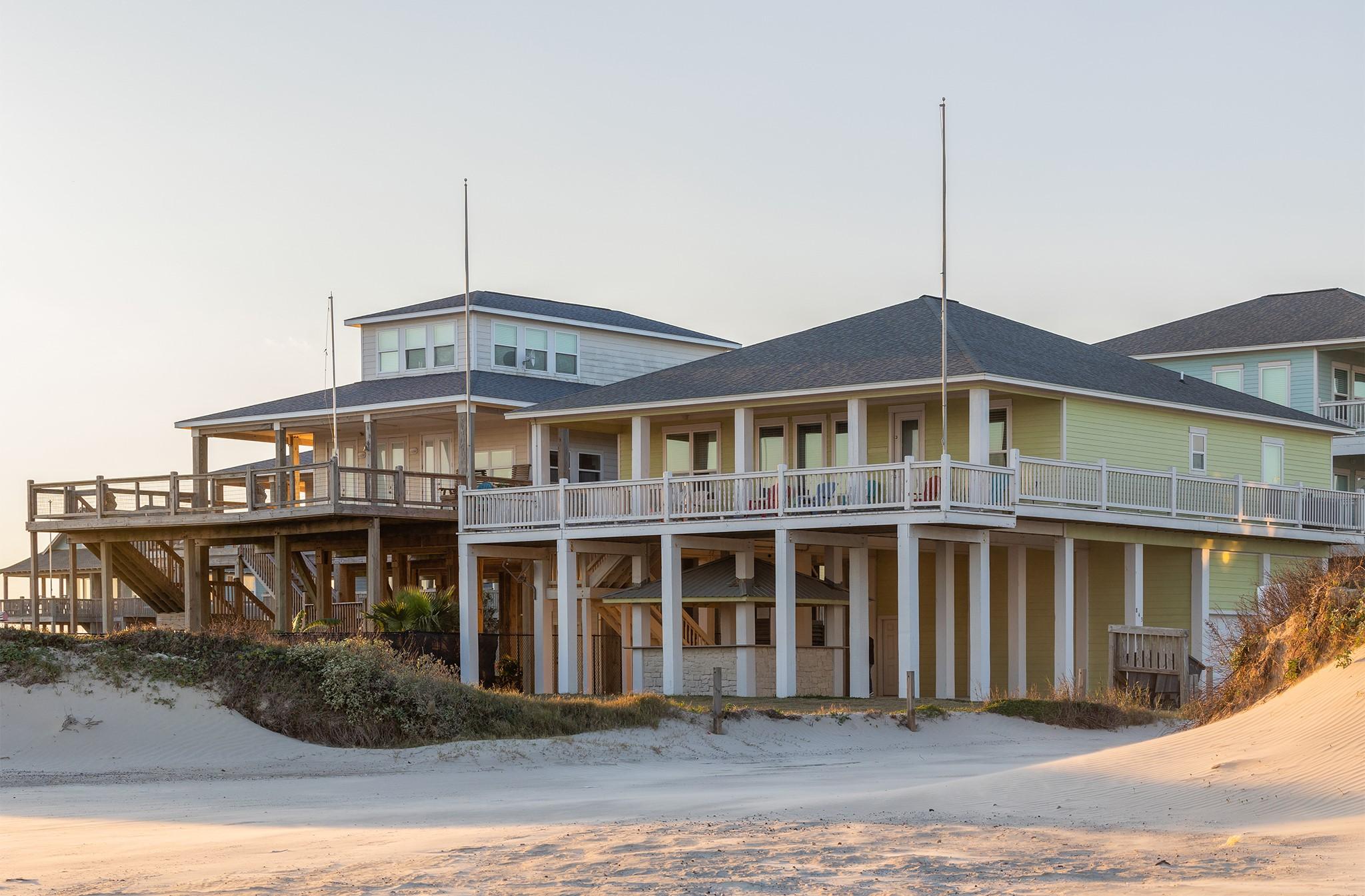 Image 2: The home is surrounded by sand dunes, offering dir