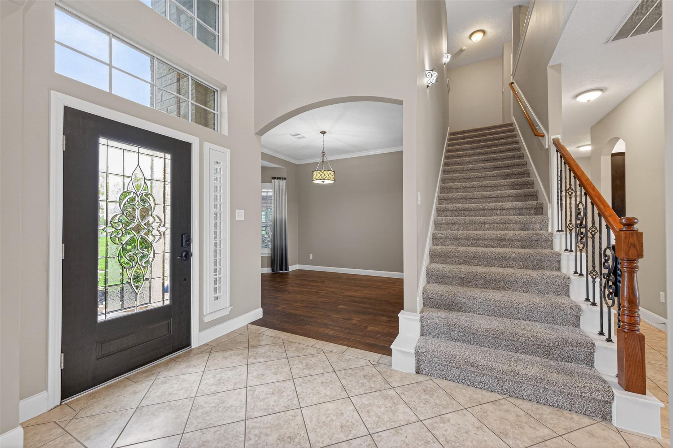 Image 3: Grand entry greets guests with glass door and iron