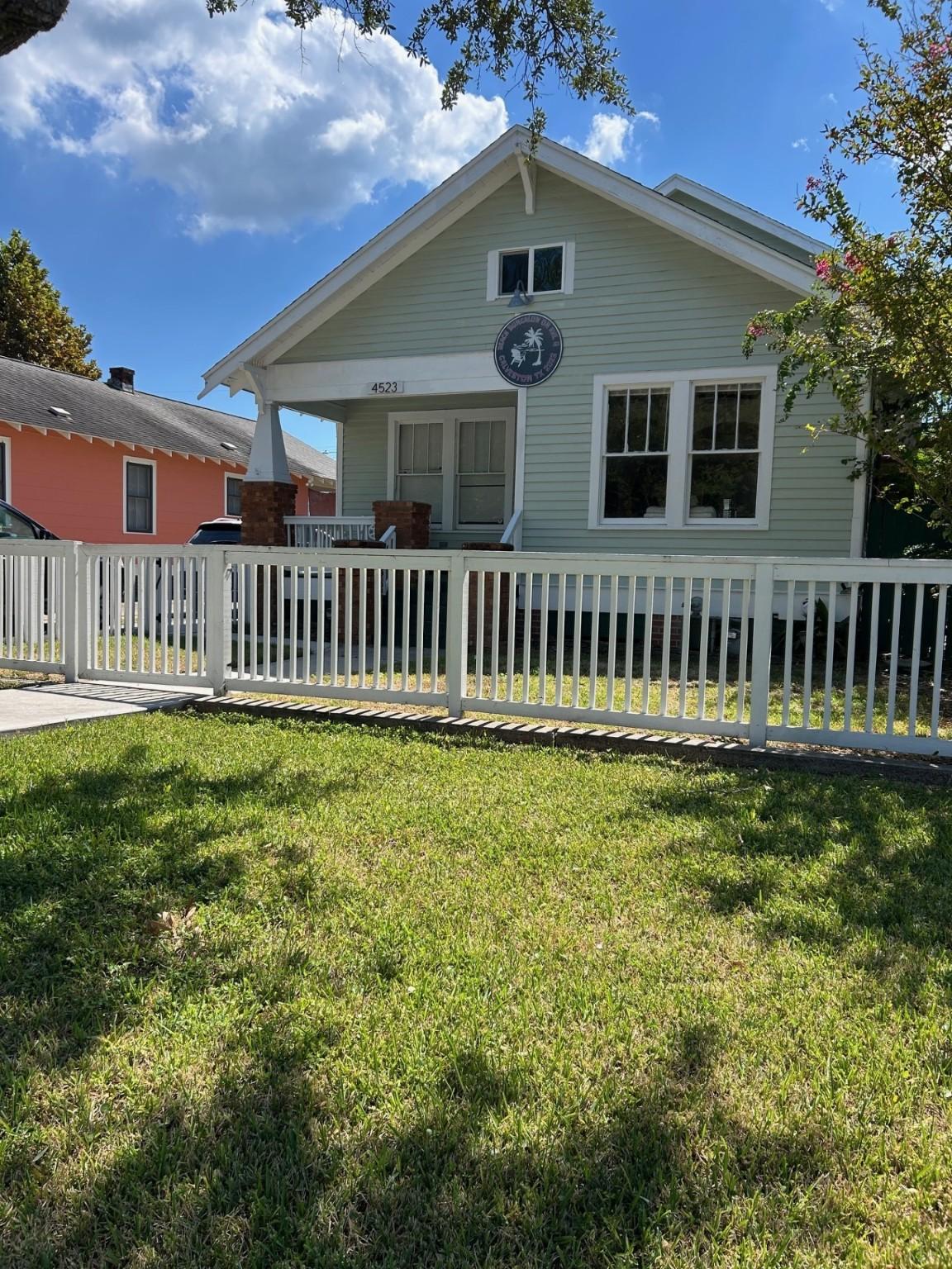 Image 1: Craftsman-style home in fenced yard.