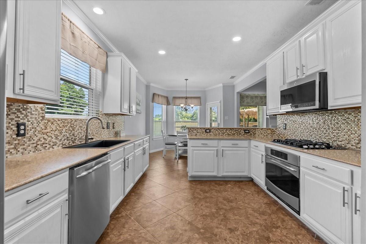 Image 3: Bright and airy kitchen with white cabinetry, upda