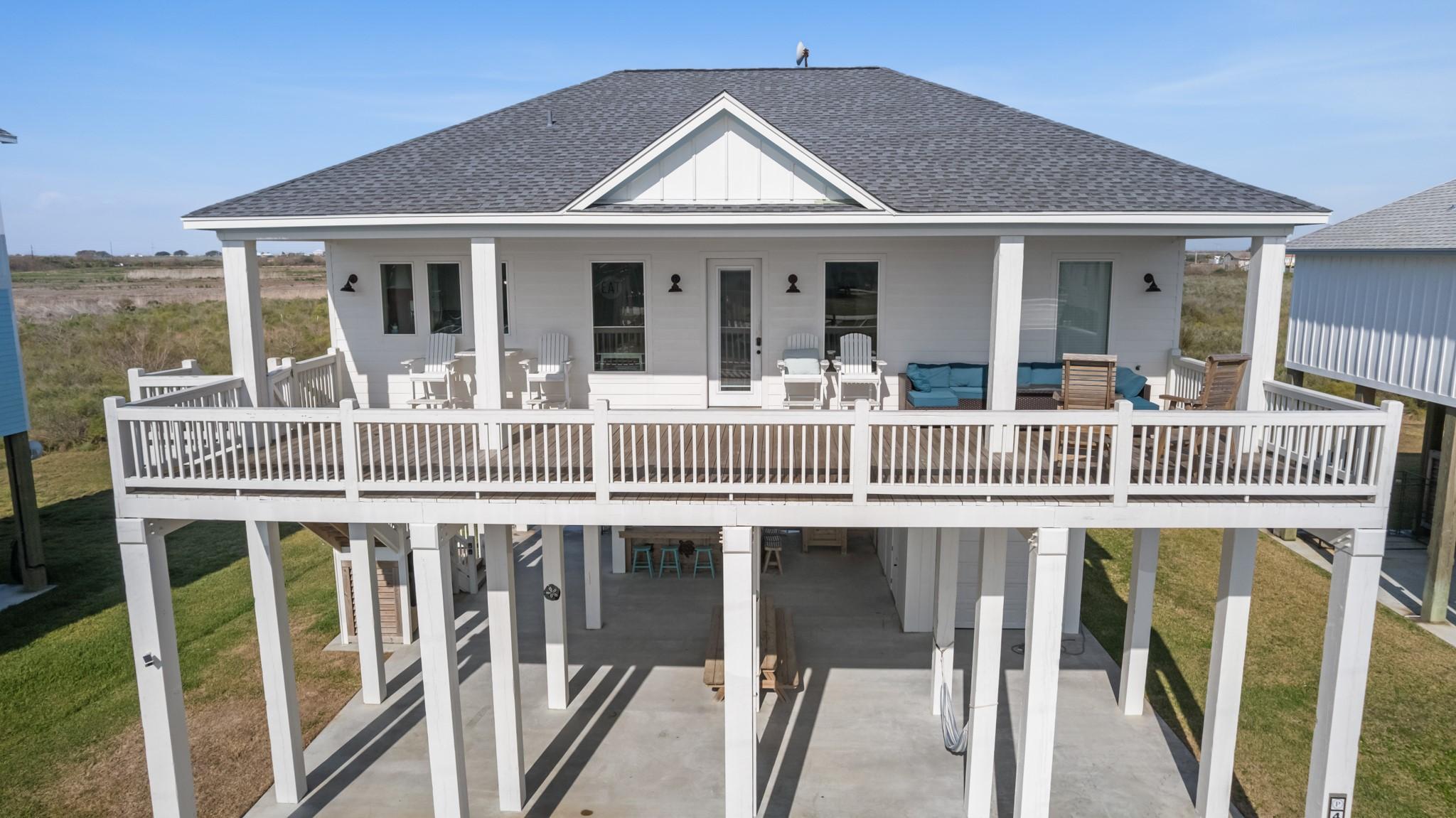 Image 2: Elevated coastal home with covered parking below,