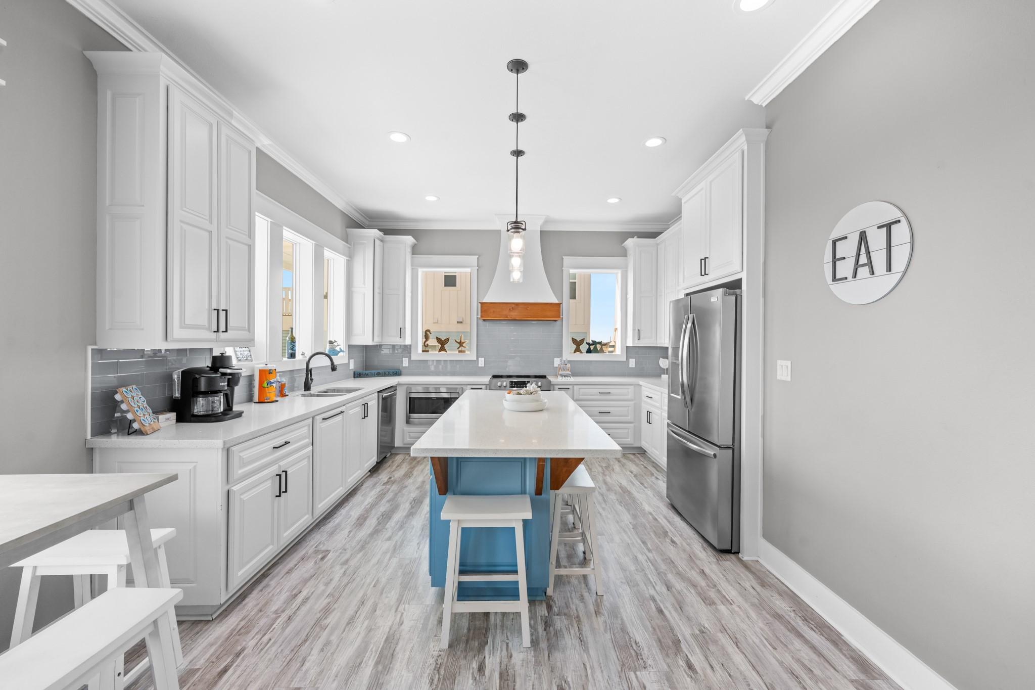 Image 4: Open-concept kitchen with white cabinetry, center