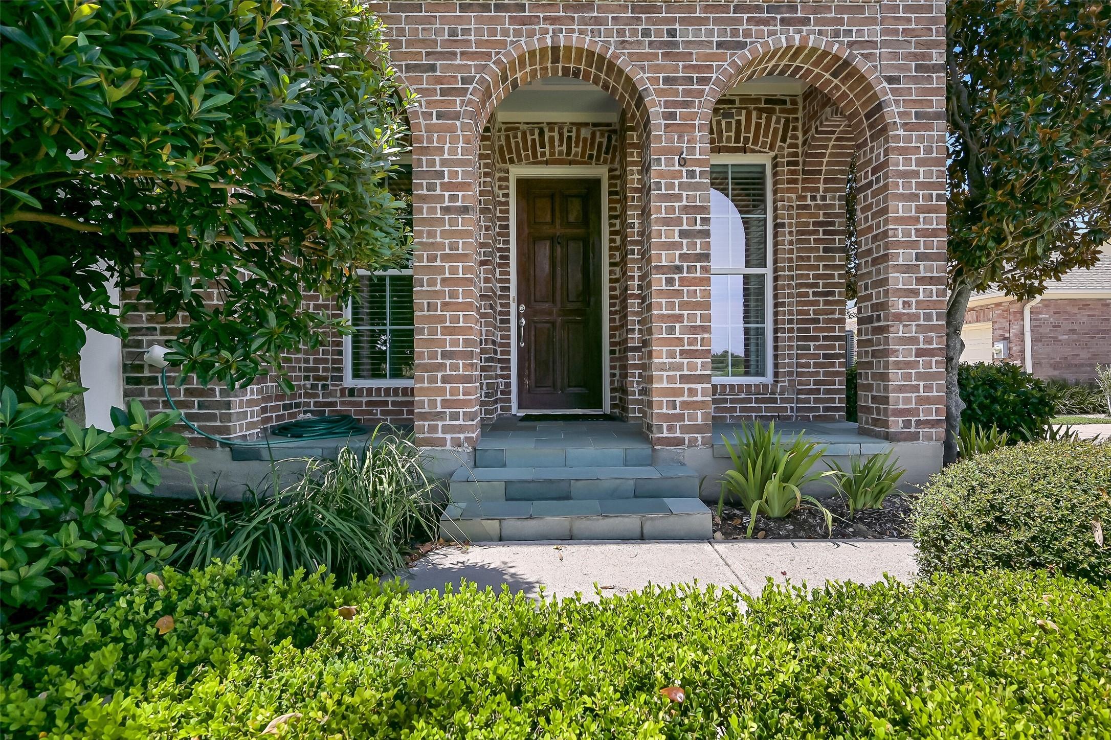 Image 2: Beautiful landscaping envelopes the townhome. This