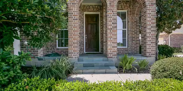 Image 2: Beautiful landscaping envelopes the townhome. This