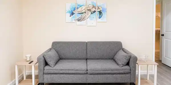 Image 4: Cozy living space featuring a stylish gray sofa wi