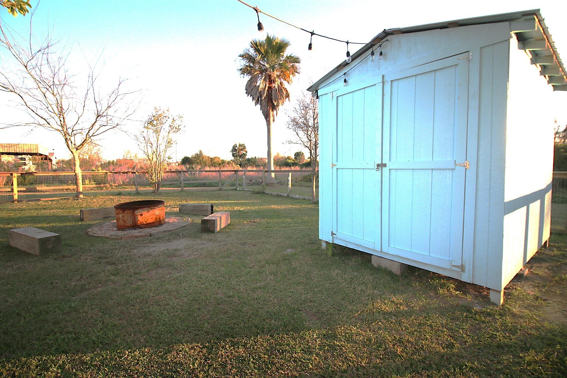 Image 2: This backyard features a spacious lawn with a ligh