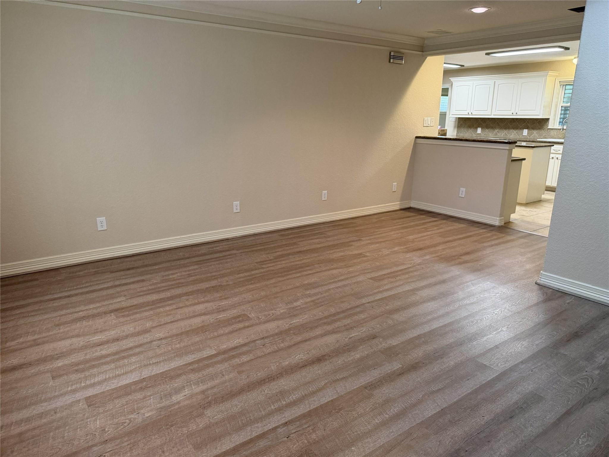 Image 2: A spacious, open living room with vinyl-plank floo