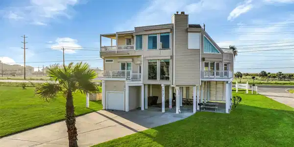 Image 2: A wide exterior view showcases the home&rsquo;s elevated