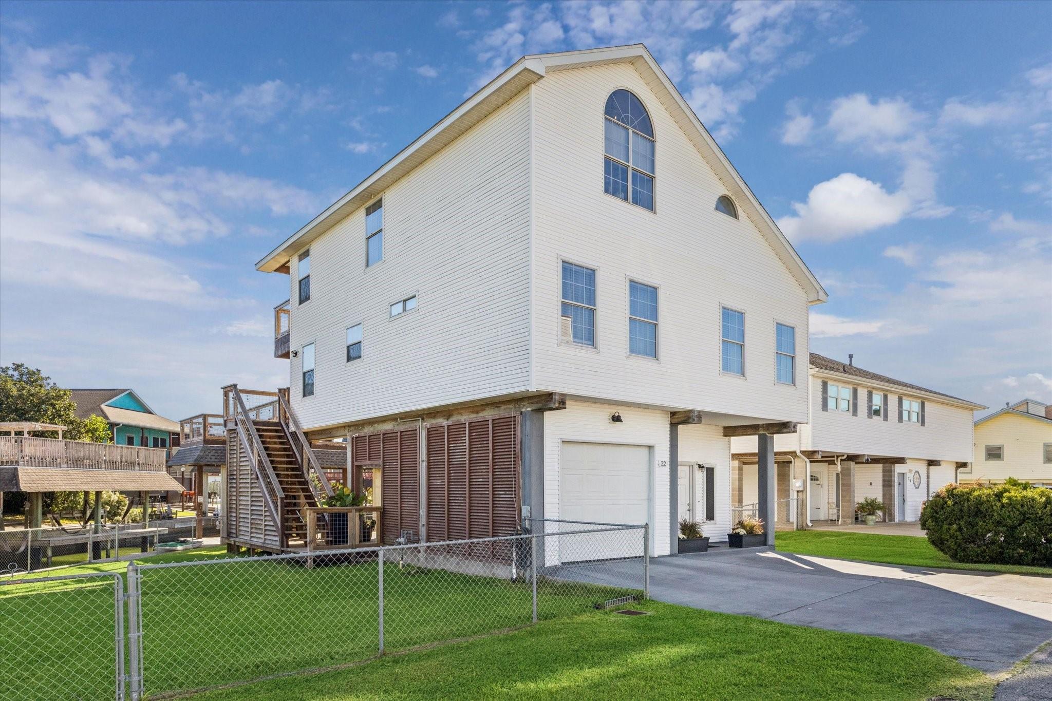 Image 3: Attached carport is louvered for privacy, with ext