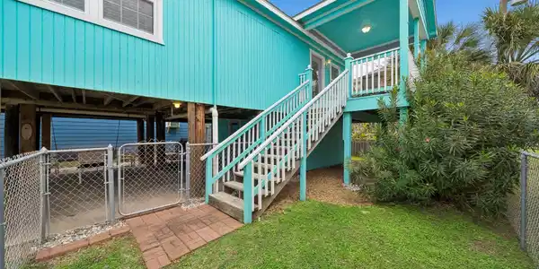 Image 2: Elevated home with exterior staircase leading to t