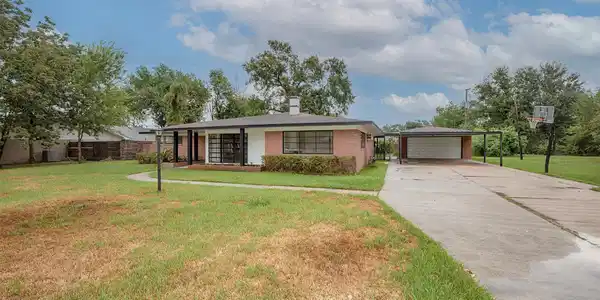 Image 2: The long driveway leads to the carport and garage.