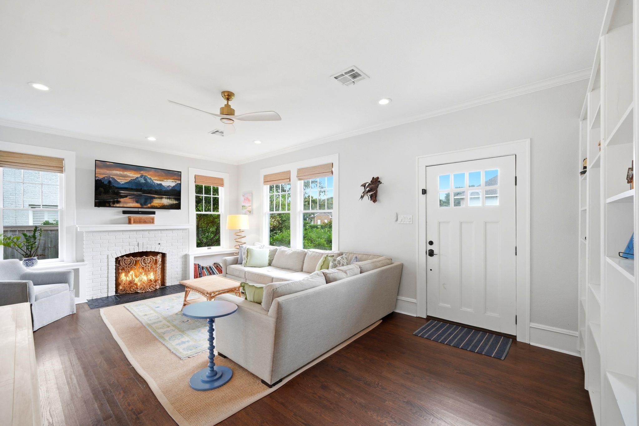 Image 3: Spacious living room with hardwood floors, large w