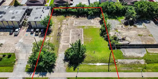 Image 3: The lot is mostly clear with some greenery and pav